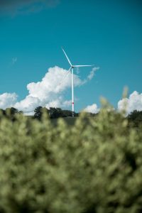 white wind turbine through green grass
